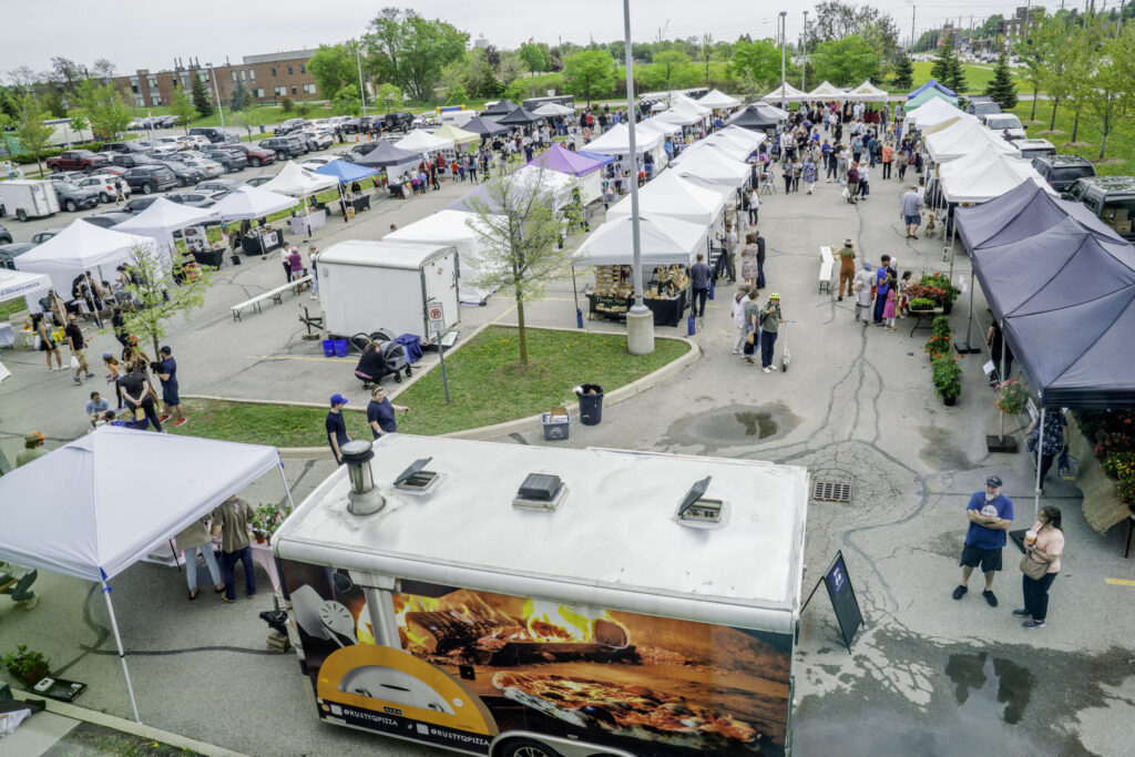 Aerial view of an outdoor street festival or market featuring multiple white vendor tents.